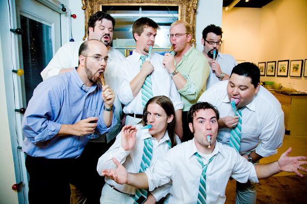 fun photo of the groomsmen goofing off with aqua colored popsicles and wearing aqua and white striped ties -photo by North Carolina based wedding photographers Cunningham Photo Artists